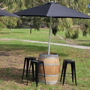 Black umbrella in wine barrel and black tolix stools